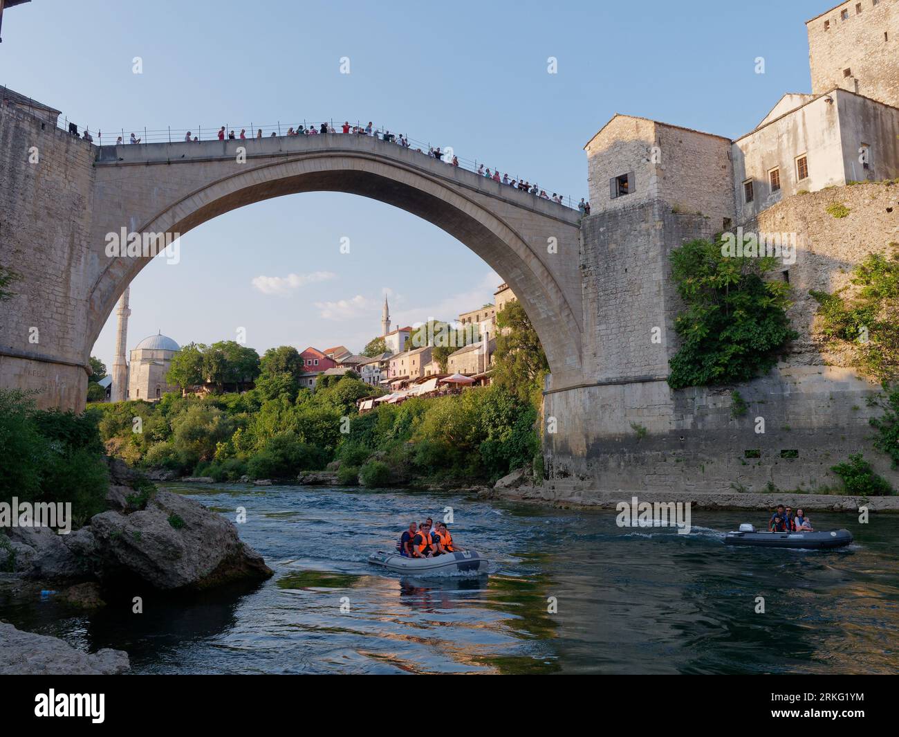Motoscafi sul fiume Neretva con turisti a Stari Most (Ponte Vecchio) e alla Moschea Koski-Mehmed Pasha a Mostar, Bosnia ed Erzegovina, 20 agosto 2023 Foto Stock
