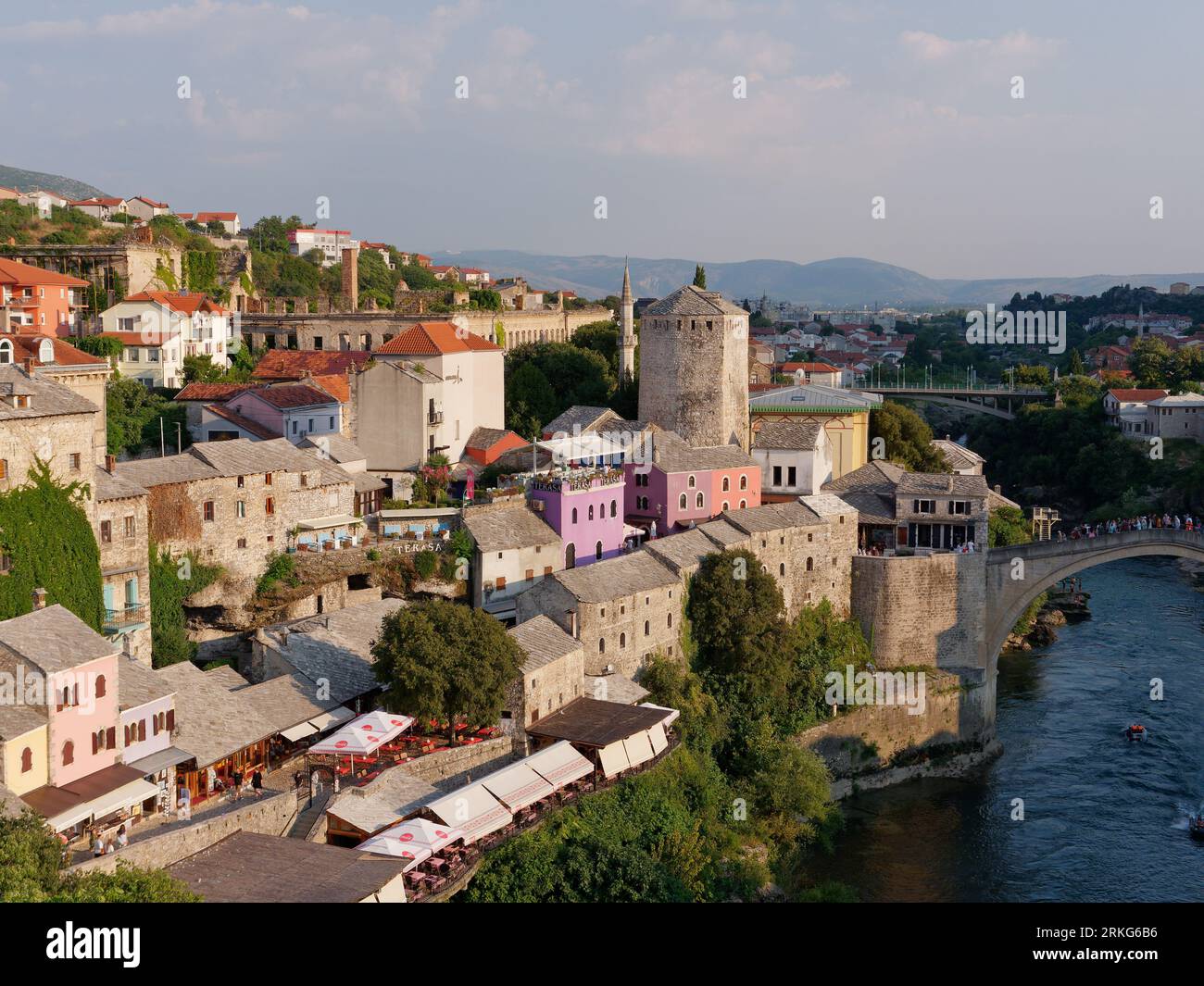 Città vecchia con caffetterie e ristoranti accanto al fiume Neretva e Stari Most (Ponte Vecchio) a Mostar, Bosnia ed Erzegovina, 22 agosto 2023. Foto Stock