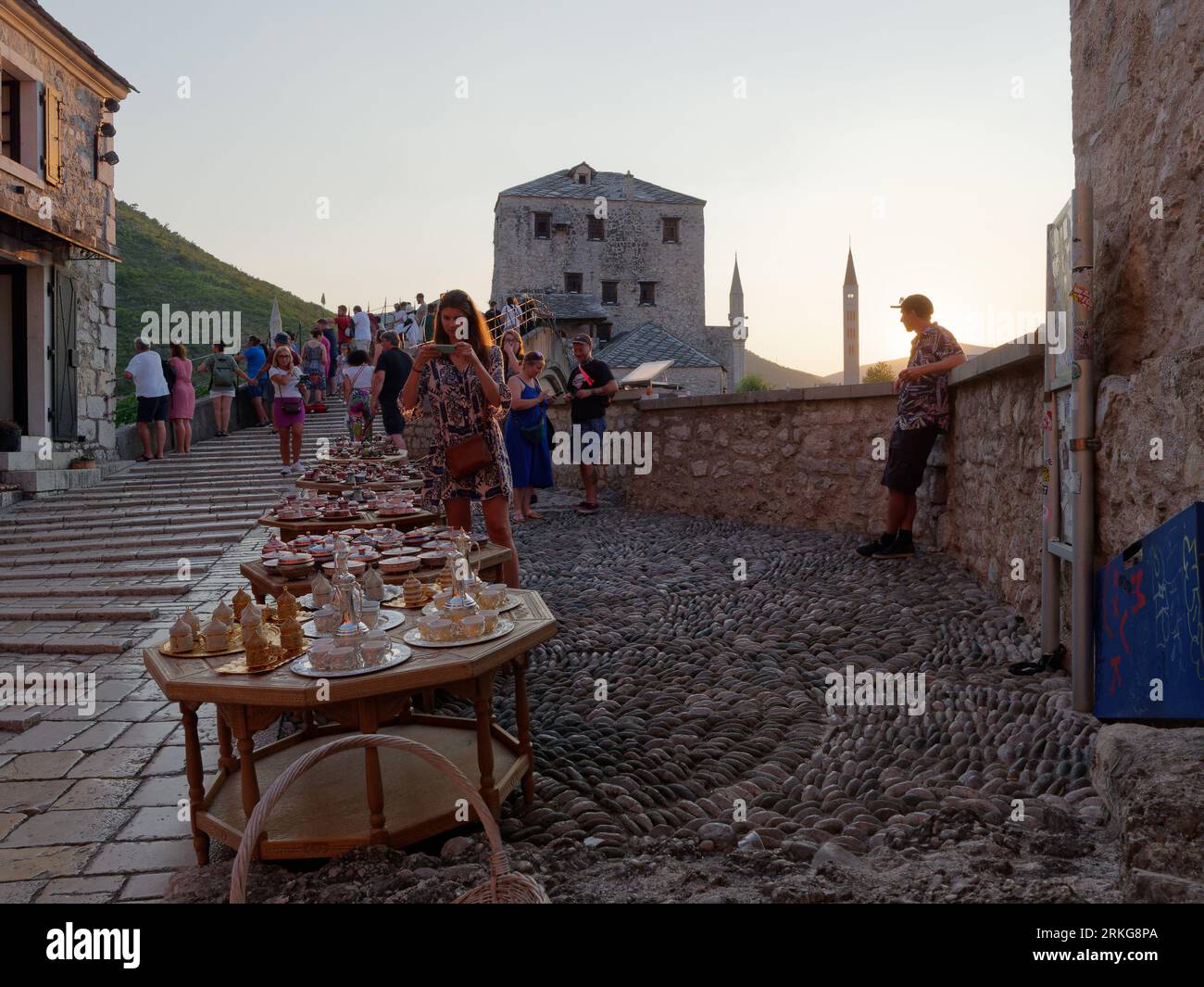 Souvenir di donne fotografiche su Stari Most (Ponte Vecchio) in una serata estiva a Mostar, Bosnia ed Erzegovina, 22 agosto 2023. Foto Stock