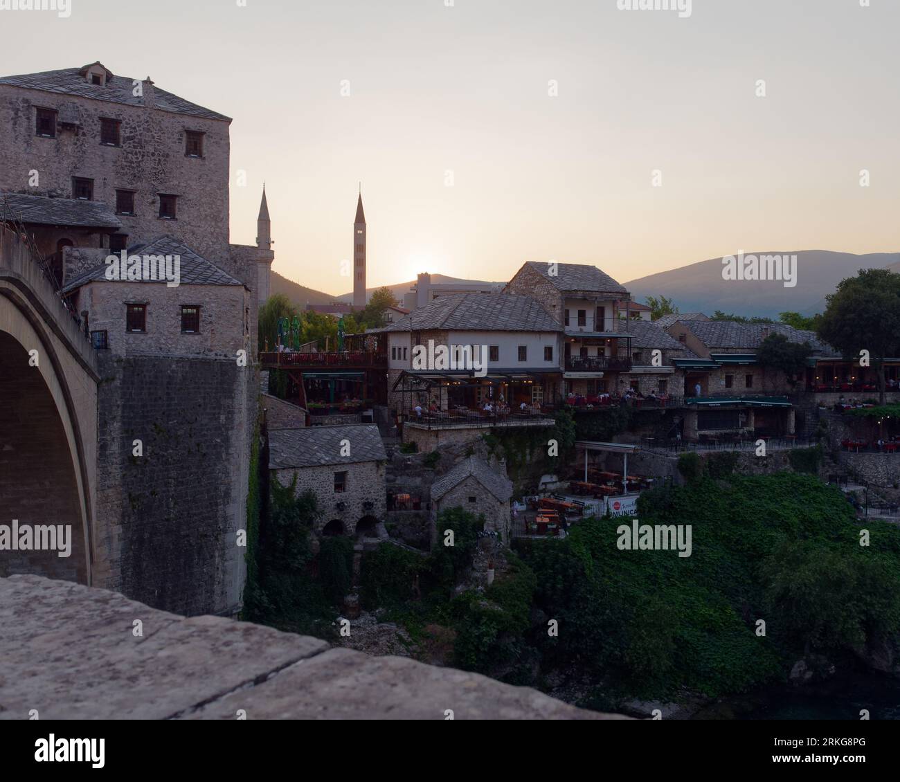 Vista da Stari Most (Ponte Vecchio) sulla città Vecchia in estate al tramonto verso il minareto di Mostar, Bosnia ed Erzegovina, 22 agosto 2023. Foto Stock