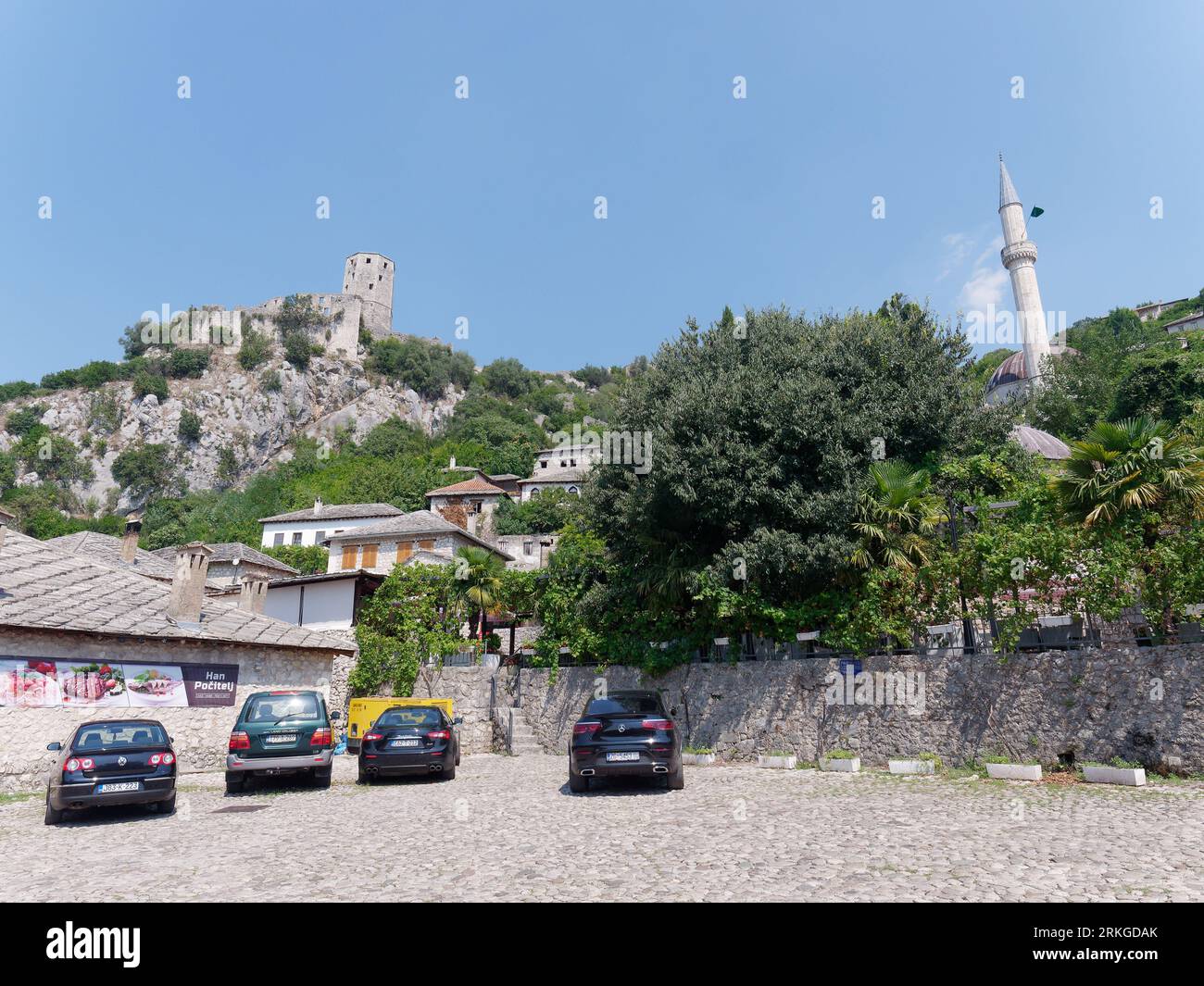 Parcheggio nel villaggio di Počitelj con il suo castello sulla collina sopra in Bosnia ed Erzegovina in un giorno estivo. 24 agosto 2023 Foto Stock