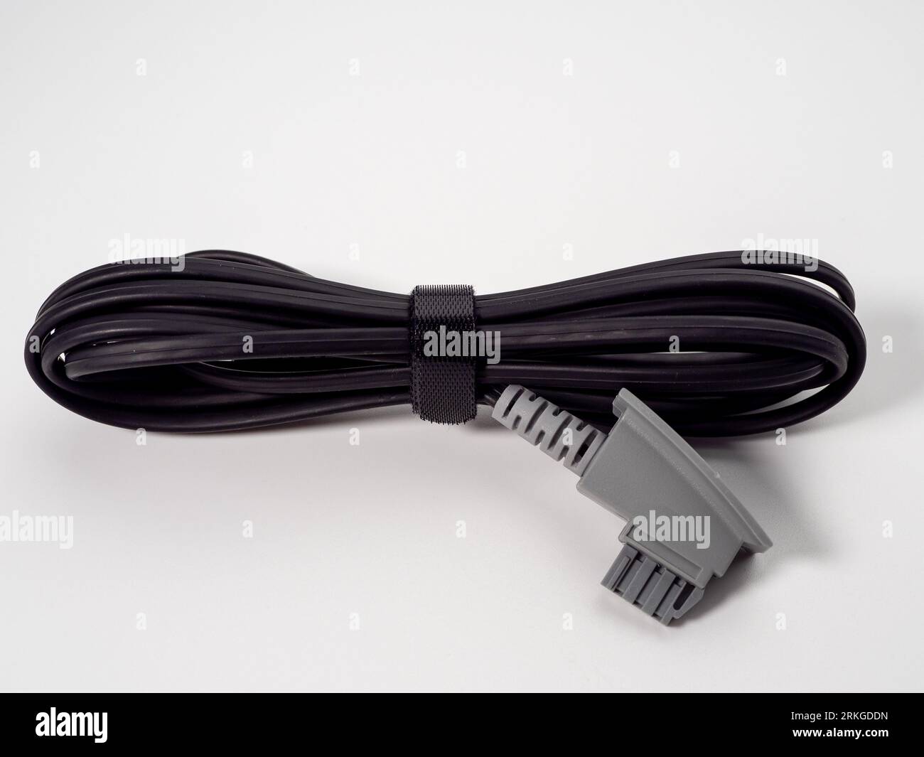 Primo piano di un adattatore per connettore maschio del telecomando collegato a un cavo di alimentazione Foto Stock