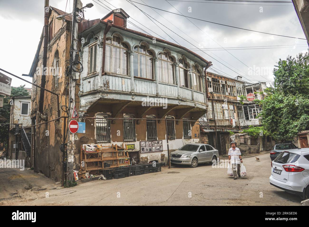 Un uomo che cammina davanti ad un edificio storico in via Gia Abesadze, Tbilisi, Georgia Foto Stock