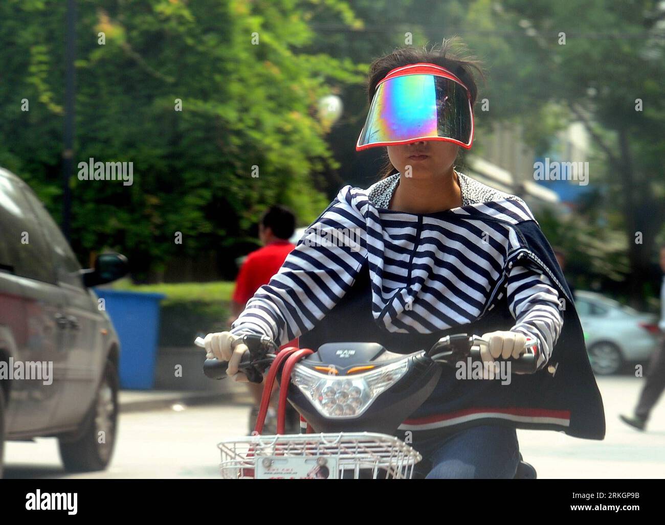 Bildnummer: 55611226 Datum: 23.07.2011 Copyright: imago/Xinhua (110723) -- SUZHOU, 23 luglio 2011 (Xinhua) -- Una donna va in bicicletta in estate calda, indossando un cappello e un abito a maniche lunghe per evitare l'esposizione al sole, a Suzhou, nella provincia di Jiangsu della Cina orientale, 23 luglio 2011. Le autorità locali del servizio meteorologico hanno emesso un allarme termico sabato, dicendo che l'ondata di calore durerebbe altri tre giorni. (Xinhua/Hang Xingwei) (ry) CHINA-JIANGSU-SUMMER HEAT (CN) PUBLICATIONxNOTxINxCHN Gesellschaft xns 2011 quer kurios Komik o0 Blende, Sonnenblende, Sonnenschutz, Sonnenbrille, Visier, Straße, Verkehr, Motorro Foto Stock