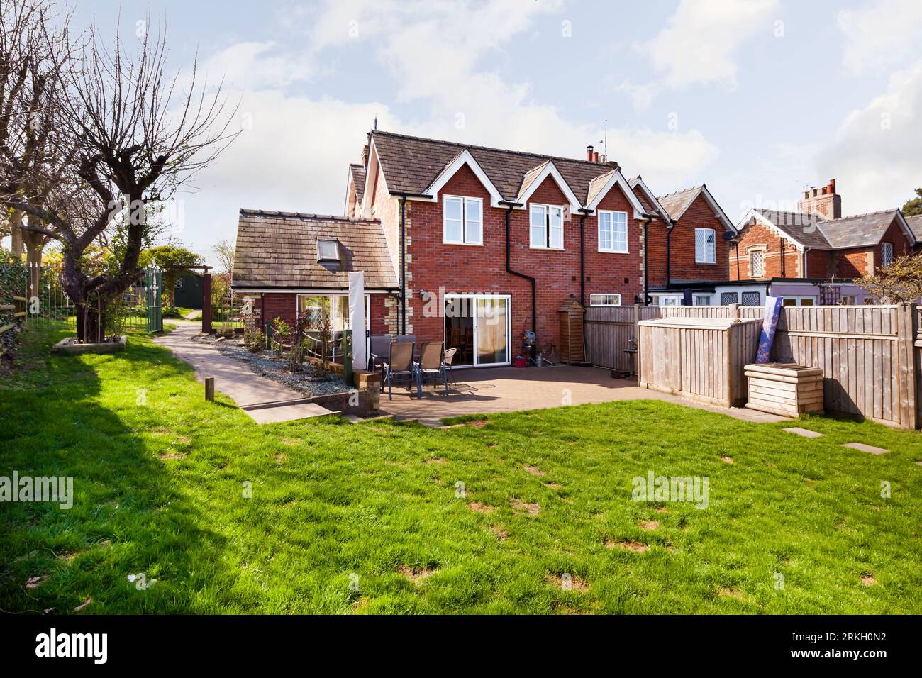 Moulton, Suffolk, Inghilterra - 1° aprile 2019: Case in mattoni tradizionali nel villaggio di suffolk, illuminate da luce solare che proietta l'ombra sul patio Foto Stock