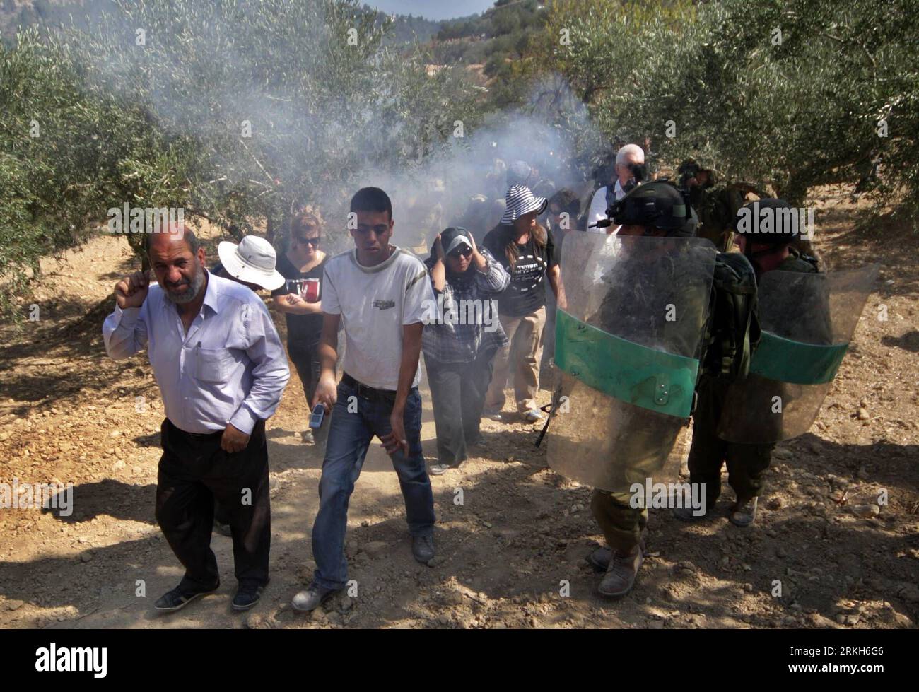 Bildnummer: 55689615 Datum: 10.08.2011 Copyright: imago/Xinhua (110810)-- CISGIORDANIA, 10 agosto 2011 (Xinhua) -- palestinesi e attivisti di pace stranieri reagiscono dalle granate sonore lanciate dai soldati israeliani durante una protesta contro la controversa barriera di separazione israeliana nel villaggio di al-Walajah, vicino a Betlemme, 10 agosto 2011. Dieci manifestanti sono stati detenuti dalle truppe israeliane durante la manifestazione, i testimoni hanno detto mercoledì. (Xinhua/Luay Sababa) MIDEAST-CISGIORDANIA-PROTESTA PUBLICATIONxNOTxINxCHN Gesellschaft Politik Demo Protest Soldat Israel Palästina Westjordanland premiumd Foto Stock