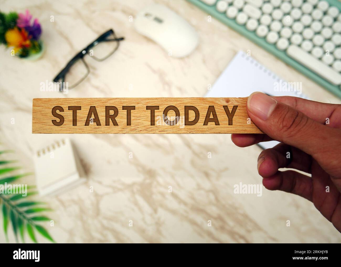 INIZIA OGGI - blocco di legno che tiene la mano con l'iscrizione Start Today. Tastiera, mouse, notebook, penna, occhiali, e il cellulare. Elenco delle cose da fare e piani f Foto Stock