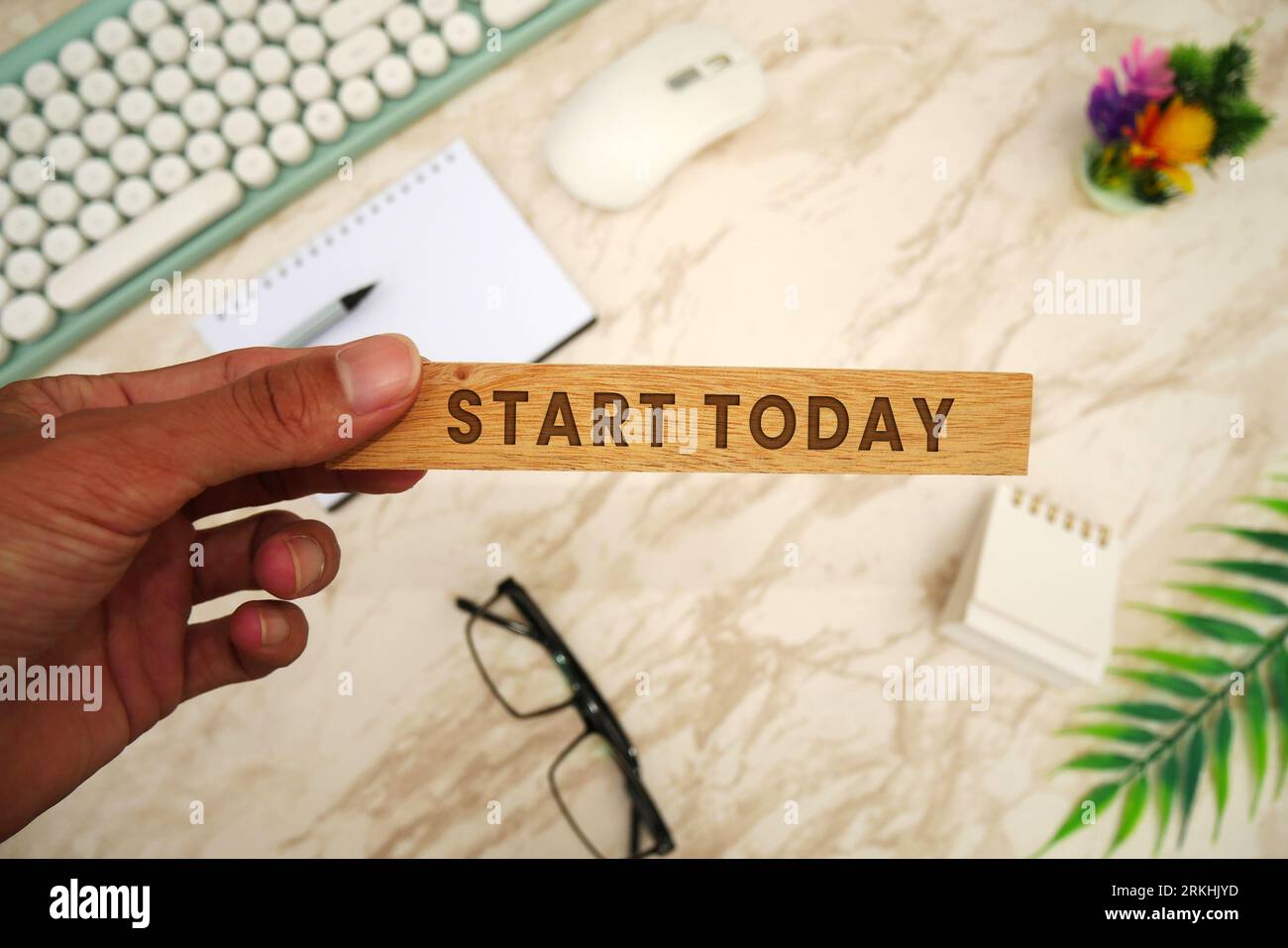 INIZIA OGGI - blocco di legno che tiene la mano con l'iscrizione Start Today. Tastiera, mouse, notebook, penna, occhiali, e il cellulare. Elenco delle cose da fare e piani f Foto Stock