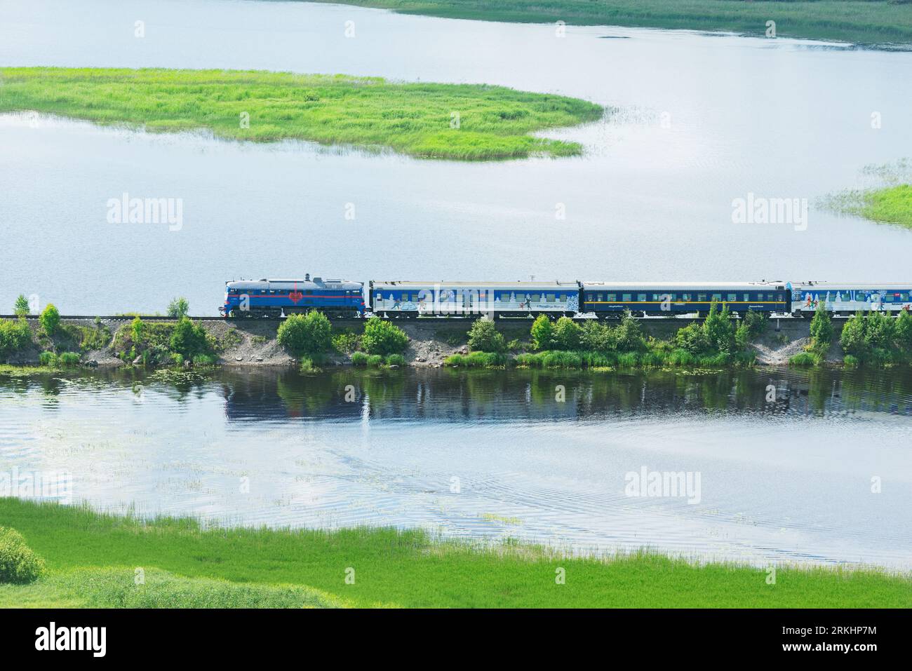 Sortavala, Russia - 15 luglio 2023: Il treno padre Frost si sposta lungo il lago. Foto Stock