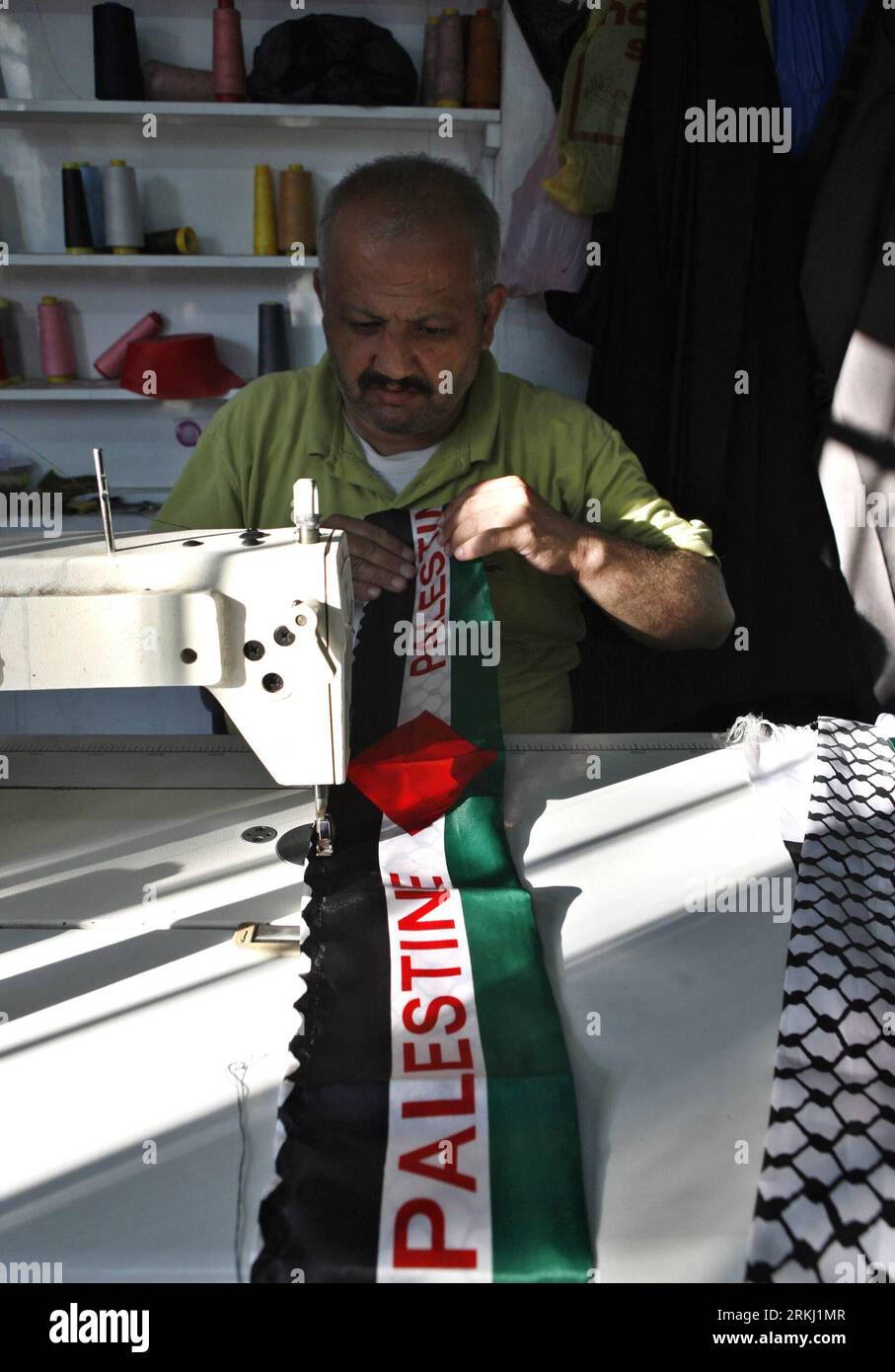 Bildnummer: 55947273 Datum: 12.09.2011 Copyright: imago/Xinhua (110912) -- NABLUS, 12 settembre 2011 (Xinhua) -- un sarto palestinese cuce bandiere nazionali da utilizzare nella campagna nazionale per promuovere l'offerta palestinese di settembre per ottenere il riconoscimento di Stato presso le Nazioni Unite, nel suo laboratorio nella città di Nablus in Cisgiordania, il 12 settembre 2011. Il Presidente palestinese Mahmoud Abbas si rivolgerà al venerdì palestinese e li informerà che la richiesta di adesione all’ONU sarebbe stata presentata attraverso il Consiglio di sicurezza, come ha detto lunedì un funzionario palestinese. (Xinhua/Ayman Nobani) (wjd) MID Foto Stock