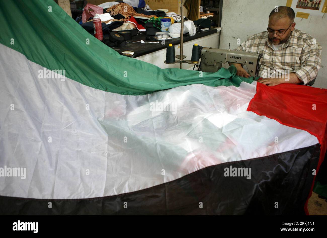 Bildnummer: 55947274 Datum: 12.09.2011 Copyright: imago/Xinhua (110912) -- NABLUS, 12 settembre 2011 (Xinhua) -- un sarto palestinese cuce bandiere nazionali da utilizzare nella campagna nazionale per promuovere l'offerta palestinese di settembre per ottenere il riconoscimento di Stato presso le Nazioni Unite, nel suo laboratorio nella città di Nablus in Cisgiordania, il 12 settembre 2011. Il Presidente palestinese Mahmoud Abbas si rivolgerà al venerdì palestinese e li informerà che la richiesta di adesione all’ONU sarebbe stata presentata attraverso il Consiglio di sicurezza, come ha detto lunedì un funzionario palestinese. (Xinhua/Ayman Nobani) (wjd) MID Foto Stock