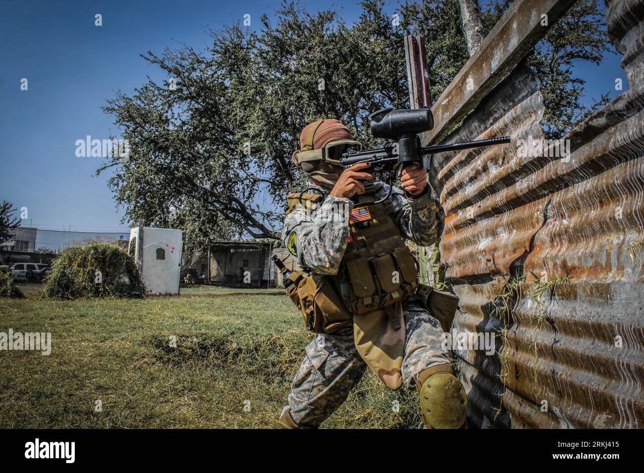 Una persona impegnata in una partita di paintball in abiti militari Foto Stock