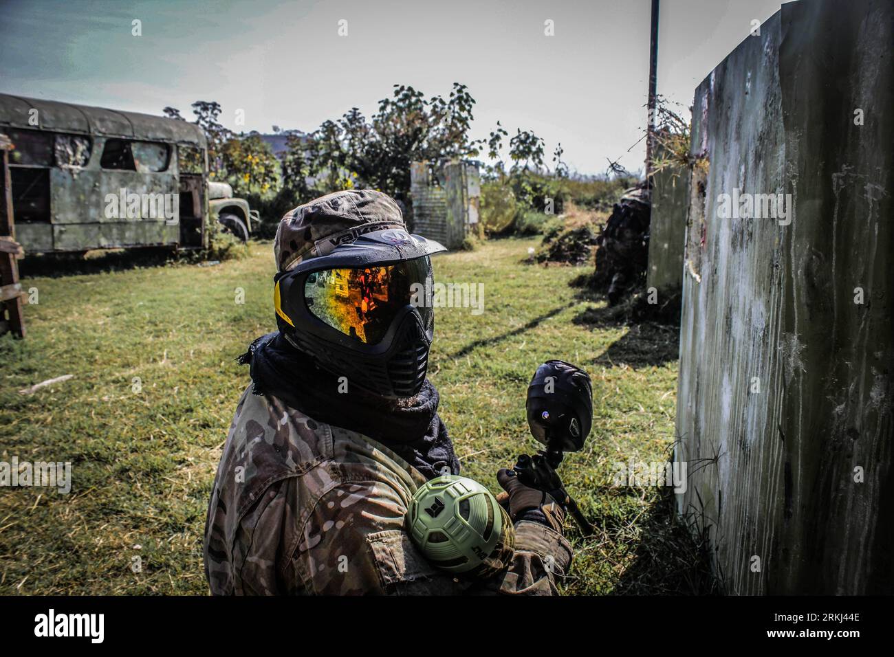 Un gruppo di persone impegnate in una partita di paintball in abiti militari Foto Stock