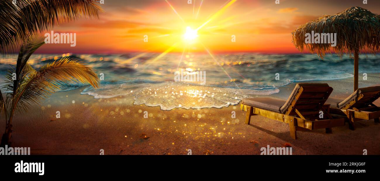 Spiaggia tropicale al tramonto - sedie a sdraio con ombrellone con scintillanti effetti di luce - sfondo sfocato astratto e messa a fuoco selettiva in primo piano Foto Stock