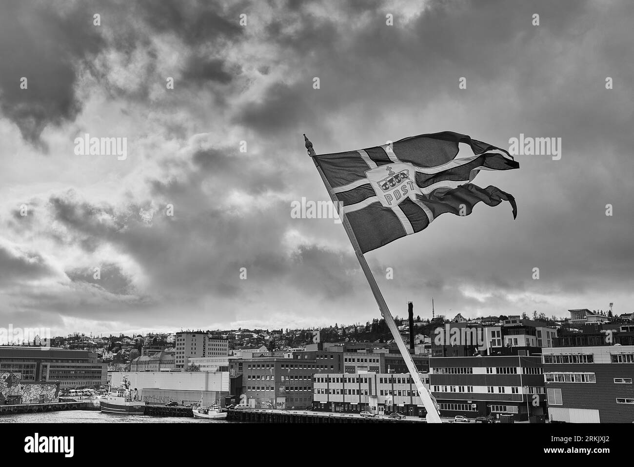 Foto in bianco e nero della bandiera norvegese (Norwegian Ensign) che vola dalla poppa della NORDNORGE ormeggiata a Tromsø, Norvegia. 5 maggio 2023 Foto Stock
