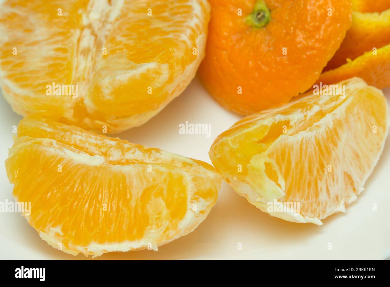 arancia preparata pronta per essere mangiata con dei segmenti vicino alla pelle Foto Stock