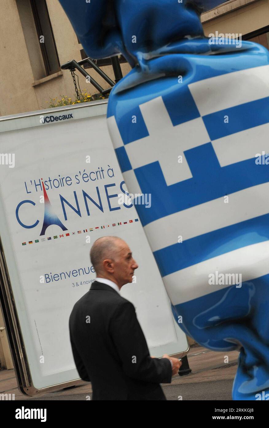 Bildnummer: 56240862 Datum: 02.11.2011 Copyright: imago/Xinhua (111102) -- CANNES, 2 NOVEMBRE 2011 (Xinhua) -- Una statua di caramelle con motivo della bandiera nazionale greca è visibile accanto a un poster del vertice del G20 a Cannes, Francia del Sud, 2 novembre 2011. I leader di Francia, Germania, Unione europea, zona euro e FMI si incontreranno con i leader greci in vista del vertice del G20 per discutere su come affrontare l'escalation della crisi del debito greco, dopo che la Grecia ha annunciato un referendum sul piano di austerità. (Xinhua/Wu Wei) FRANCIA-CANNES-G20-REFERENDUM GRECO PUBLICATIONxNOTxINxCHN Politik G20 G 20 Gipfel Weltwirtschaftsgipfel x2x xsk 2011 h Foto Stock