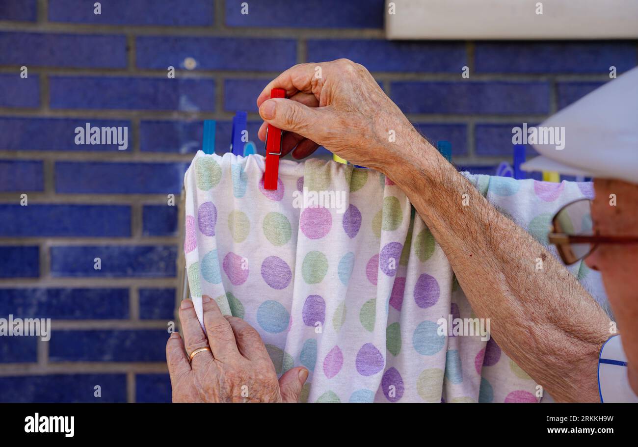 uomo maturo irriconoscibile che pende il bucato Foto Stock