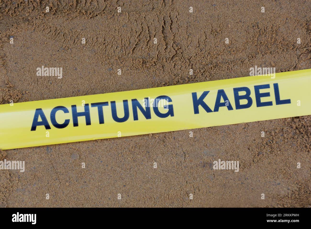 Nastro segnaletico con la dicitura tedesca "Achtung Kabel" (cavo di attenzione) cavi sotterranei nella trincea Foto Stock