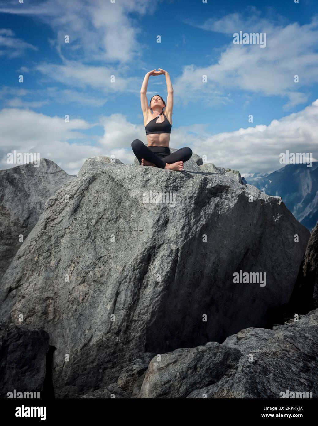 donna che pratica yoga sulla cima di una montagna Foto Stock