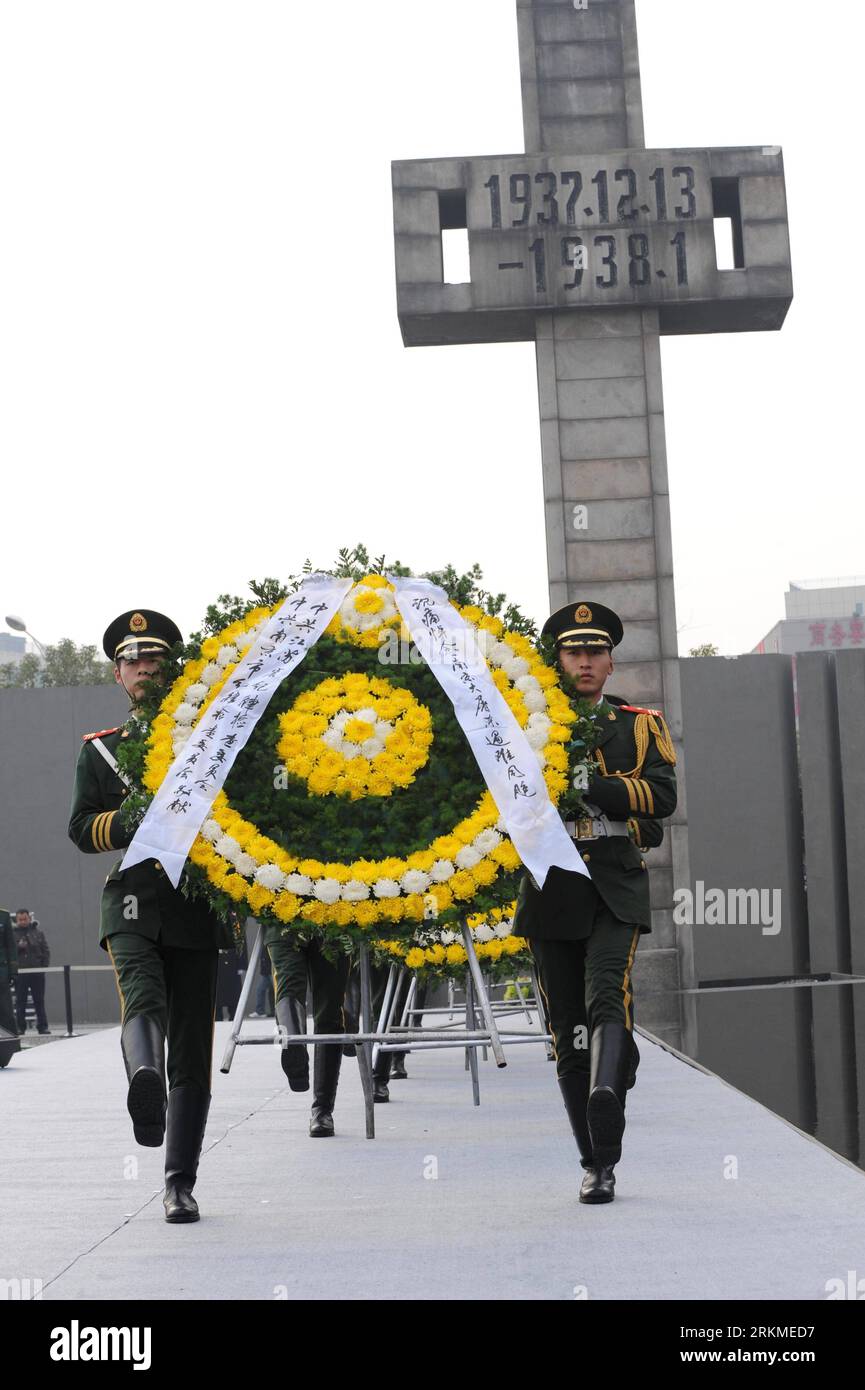 Bildnummer: 56693209 Datum: 13.12.2011 Copyright: imago/Xinhua (111213) -- NANCHINO, 13 dicembre 2011 (Xinhua) -- i membri della polizia armata del popolo cinese trasportano ghirlande in un'assemblea di pace tenuta per piangere le vittime del massacro di Nanchino a Nanchino, capitale della provincia di Jiangsu della Cina orientale, 13 dicembre 2011. Nanchino, una città che fu occupata il 13 dicembre 1937 dalle truppe giapponesi che iniziarono un massacro di sei settimane, tenne martedì un'assemblea di pace per commemorare il 74° anniversario del massacro di Nanchino. I registri mostrano più di 300.000 soldati disarmati cinesi e civili uccisi. (Xinhua/Sun Foto Stock