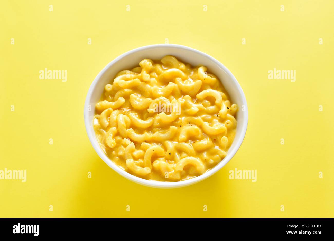 Mac e formaggio in ciotola su sfondo giallo. Vista ravvicinata Foto Stock
