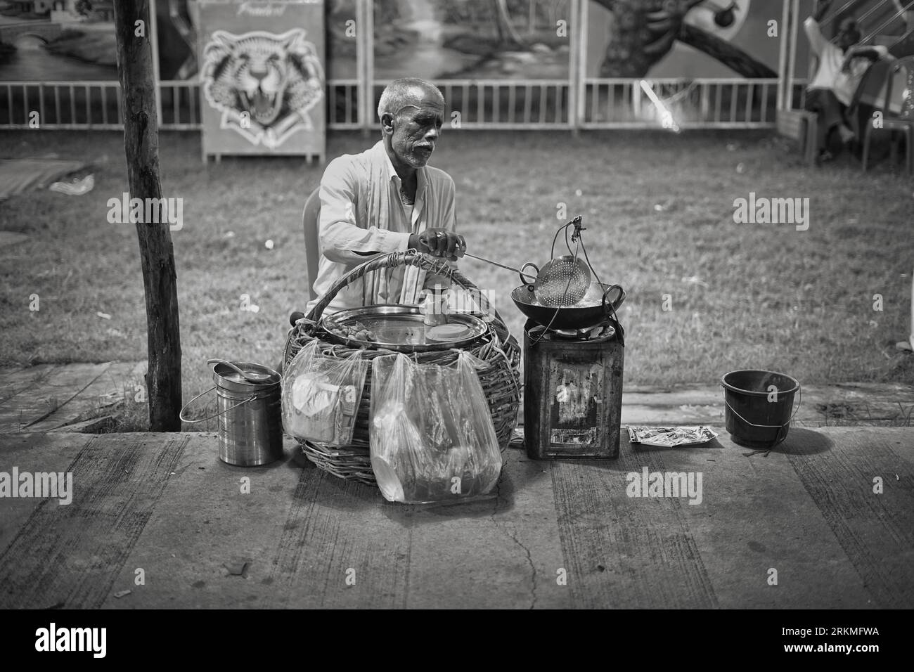 Il vecchio sta friggendo Samosa (cibo indiano) in un piccolo locale per preparare cibo per le strade dell'India. Foto Stock