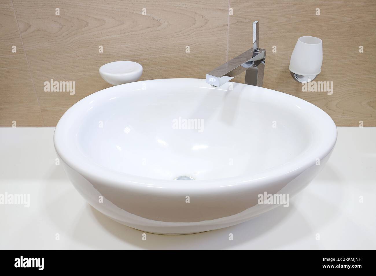 Rubinetto cromato con lavandino in ceramica bianca all'interno del bagno Foto Stock Rubinetto cromato con lavandino in ceramica bianca all'interno del bagno Foto Stock