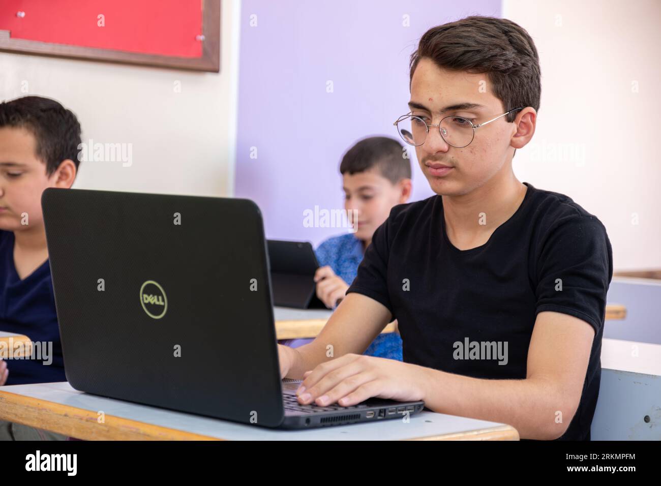 adolescente arabo che usa un computer portatile mentre studia a scuola Foto Stock