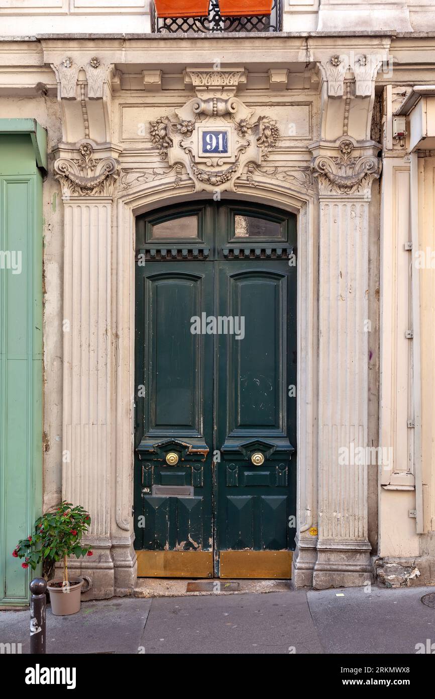 Bellissimo ingresso d'ingresso vecchio stile con facciata ocra e porta verde con decorazioni elaborate, nel quartiere di Montmartre, Parigi, Francia, Europa Foto Stock