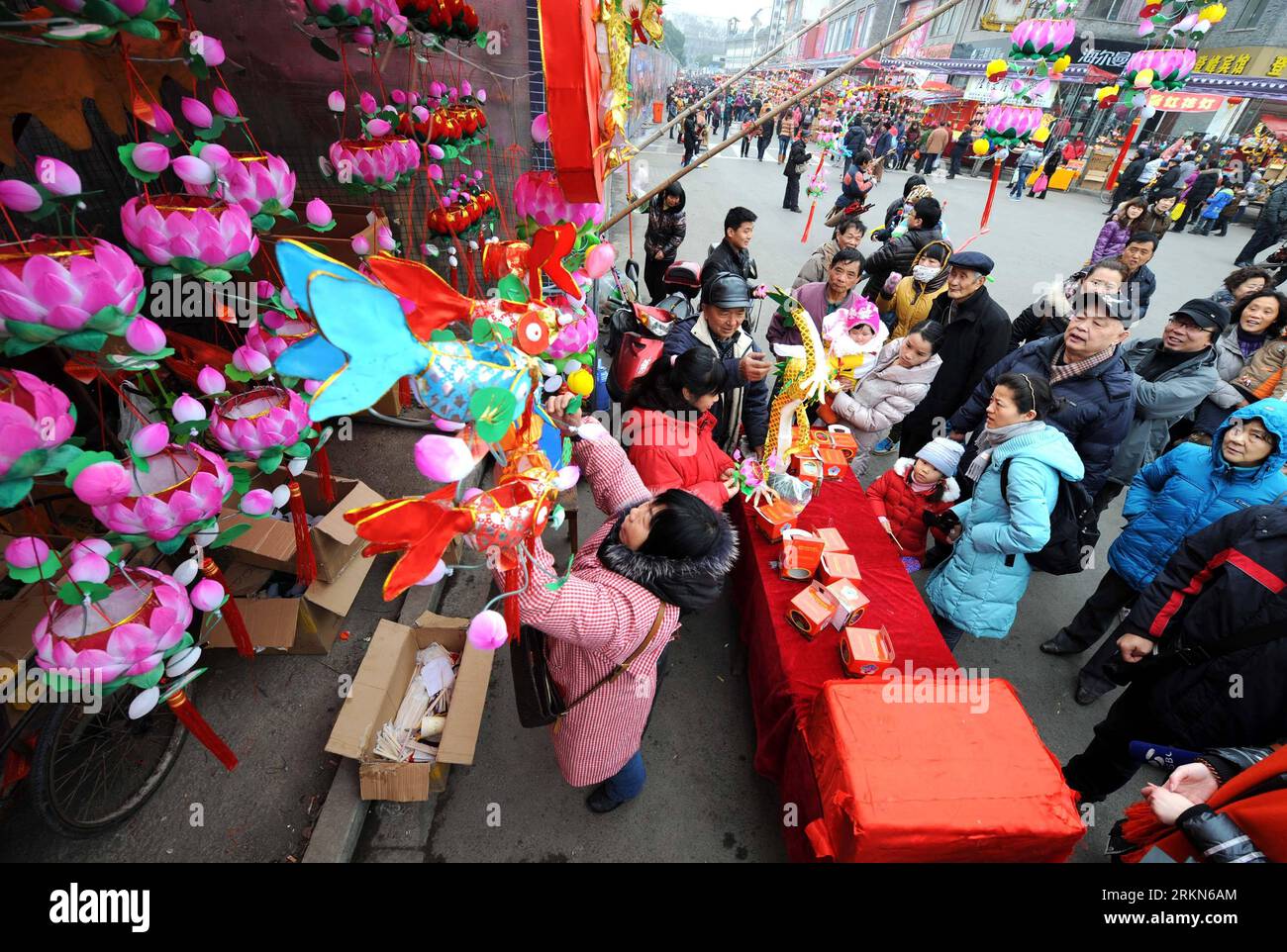 Bildnummer: 57000676 Datum: 01.02.2012 Copyright: imago/Xinhua (120201) -- NANCHINO, 1 febbraio 2012 (Xinhua) -- Cao Zhenrong e sua moglie vendono lanterne nel suo stand a Nanchino, capitale della provincia di Jiangsu della Cina orientale, 1 febbraio 2012. Cao Zhenrong, l'erede del patrimonio culturale immateriale provinciale di Jiangsu, iniziò a fare lanterne da quando aveva cinque anni e si dedicò alla carriera delle lanterne per più di 60 anni. Ha detto che non era facile creare una lanterna che ha bisogno di dozzine di processi. Fece lanterne non per soldi, ma per l'eredità delle abilità produttive di lanterne. (Xinhua/Sun CAN) (zkr Foto Stock