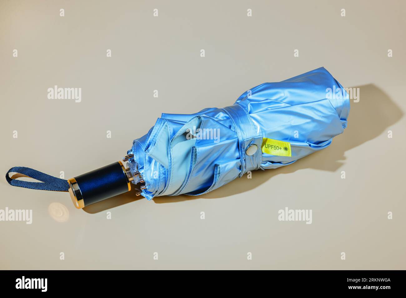 Vista ravvicinata dell'ombrellone in argento con protezione uv isolata su sfondo beige. Foto Stock