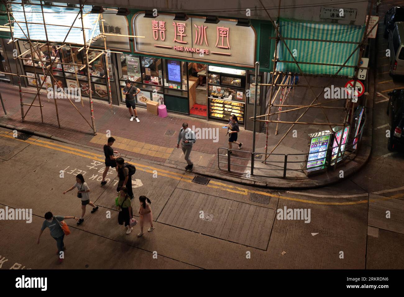 Scena di strada serale, con impalcature di bambù, angolo di Tung Choi Street, a Mongkok, Kowloon, Hong Kong, Cina agosto 2023 Foto Stock
