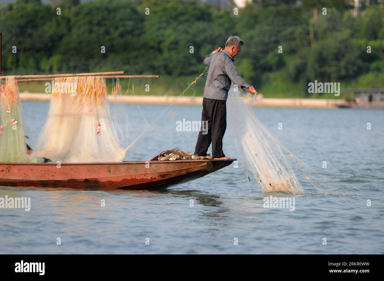 Bildnummer: 58224385 Datum: 07.07.2012 Copyright: imago/Xinhua (120711) -- LIUZHOU, 11 luglio 2012 (Xinhua) -- Un pescatore tira fuori la sua rete da pesca per catturare piranha a Liuzhou, nella regione autonoma del Guangxi Zhuang della Cina sud-occidentale, 10 luglio 2012. Wei Yongwen, capo del Liuzhou Aquatic Animal Husbandry and Veterinary Bureau, ha detto martedì che chiunque catturi un piranha nel fiume Liujiang sarà ricompensato 1.000 yuan (158,2 dollari USA). (Xinhua/li Bin) (cl) CHINA-GUANGXI-LIUZHOU-PIRANHA (CN) PUBLICATIONxNOTxINxCHN Gesellschaft Fotostory Tiere Fisch Piranha Einwanderung xjh x2x premiumd Foto Stock