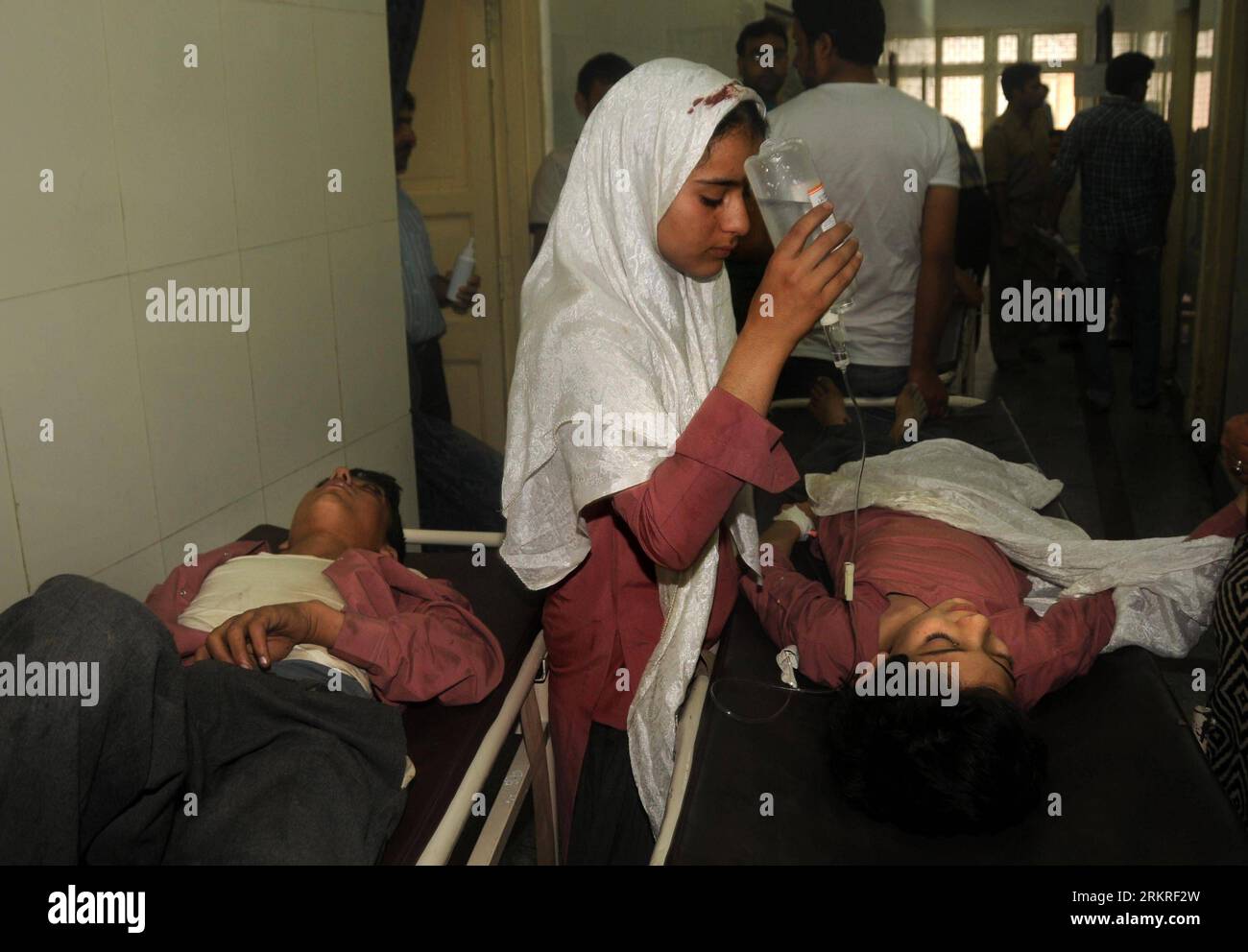 Bildnummer: 58225412 Datum: 11.07.2012 Copyright: imago/Xinhua (120711) -- SRINAGAR, 11 luglio 2012 (Xinhua) -- Una studentessa tiene la bottiglia di fluido endovenoso del suo compagno di classe all'interno del corridoio di un ospedale a Srinagar, la capitale estiva del Kashmir controllato dagli indiani, 11 luglio 2012. Almeno tre sono stati uccisi e altri 33 per lo più studenti sono rimasti feriti mercoledì dopo che uno scuolabus che li trasportava in un luogo da picnic è caduto in una gola nel Kashmir controllato dagli indiani, ha detto la polizia. (Xinhua Photo/Javed Dar) (ybg) KASHMIR-SRINAGAR-SCUOLABUS-INCIDENTE PUBLICATIONxNOTxINxCHN Gesellschaft Verkehr Unfa Foto Stock