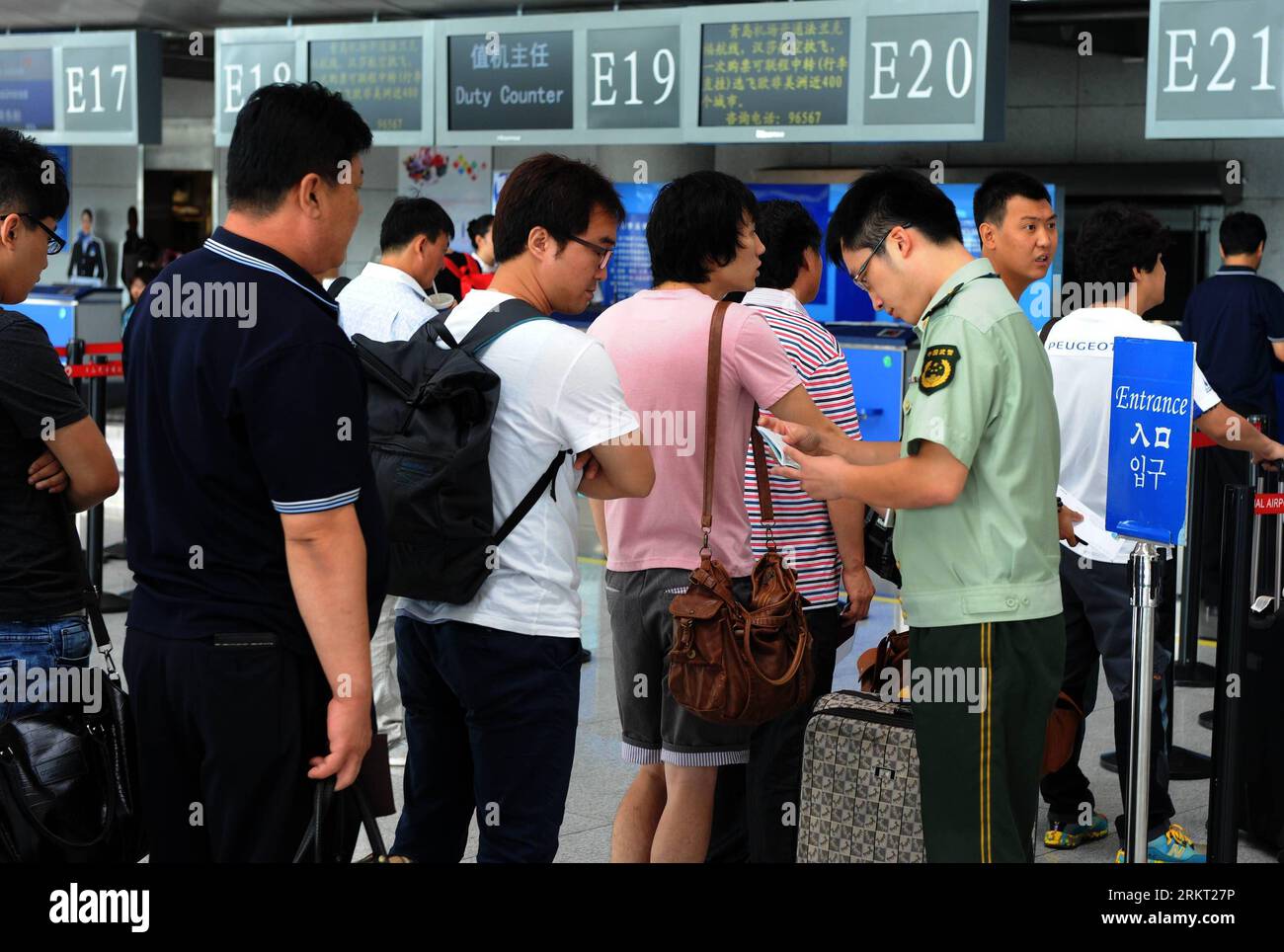 120816 -- QINGDAO, 16 agosto 2012 Xinhua -- un funzionario dell'immigrazione serve i passeggeri all'aeroporto di Qingdao a Qingdao, una città costiera nella provincia dello Shandong della Cina orientale, 16 agosto 2012. Il numero di turisti in partenza a Qingdao è in aumento dall'inizio di agosto, in crescita del 23,3% rispetto agli anni precedenti. Il flusso di ingresso e uscita più alto in un solo giorno ha raggiunto 7.144, superando il record registrato durante i Giochi Olimpici di Pechino. Xinhua/li Ziheng cl CHINA-QINGDAO-TOURISM CN PUBLICATIONxNOTxINxCHN Foto Stock