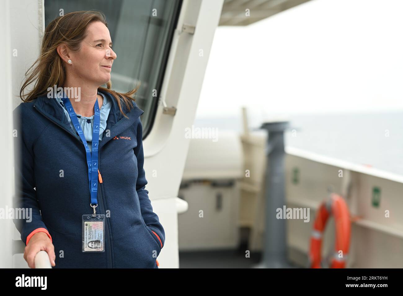 PRODUZIONE - 25 agosto 2023, bassa Sassonia, Cuxhaven: Carolin Abromeit, responsabile della protezione ambientale marittima, Agenzia federale marittima e idrografica (BSH) a bordo del BP82 "BAMBERGA" in un viaggio di monitoraggio nel Mare del Nord. Con il drone nel Mare del Nord alla ricerca di delinquenti ambientali, nel Mare del Nord e nel Mar Baltico, si applicano limiti rigorosi alle emissioni delle navi. Monitorarli è una sfida per le autorità. Per la prima volta in Germania, un drone viene utilizzato a tale scopo in una delle rotte di navigazione più trafficate del mondo. Il sistema dei droni è fornito dalla sicurezza marittima europea Foto Stock