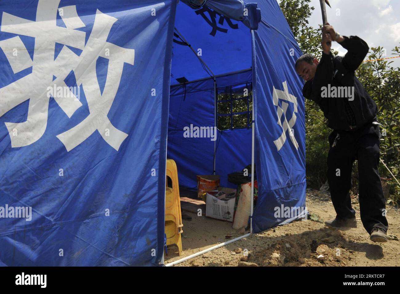 Bildnummer: 58446457 Datum: 08.09.2012 Copyright: imago/Xinhua (120908) -- WEINING, 8 settembre 2012 (Xinhua) -- Un soccorritore rafforza una tenda di rilievo nel villaggio di Jianjiao della contea di Weining, nella provincia di Guizhou della Cina sud-occidentale, 8 settembre 2012. Due terremoti di magnitudo 5,7 e 5,6 colpirono una zona di confine vicino alla contea di Yiliang nello Yunnan e la contea di Weining nella provincia di Guizhou rispettivamente alle 11:19 e alle 12:16 di venerdì, seguiti da numerose scosse di postumi. Cinquecento tende, 28.500 set di vestiti e trapunte, acqua e cibo sono stati distribuiti ai locali di Guizhou. (Xinhua/Ou Dongqu)(mcg) CINA- Foto Stock