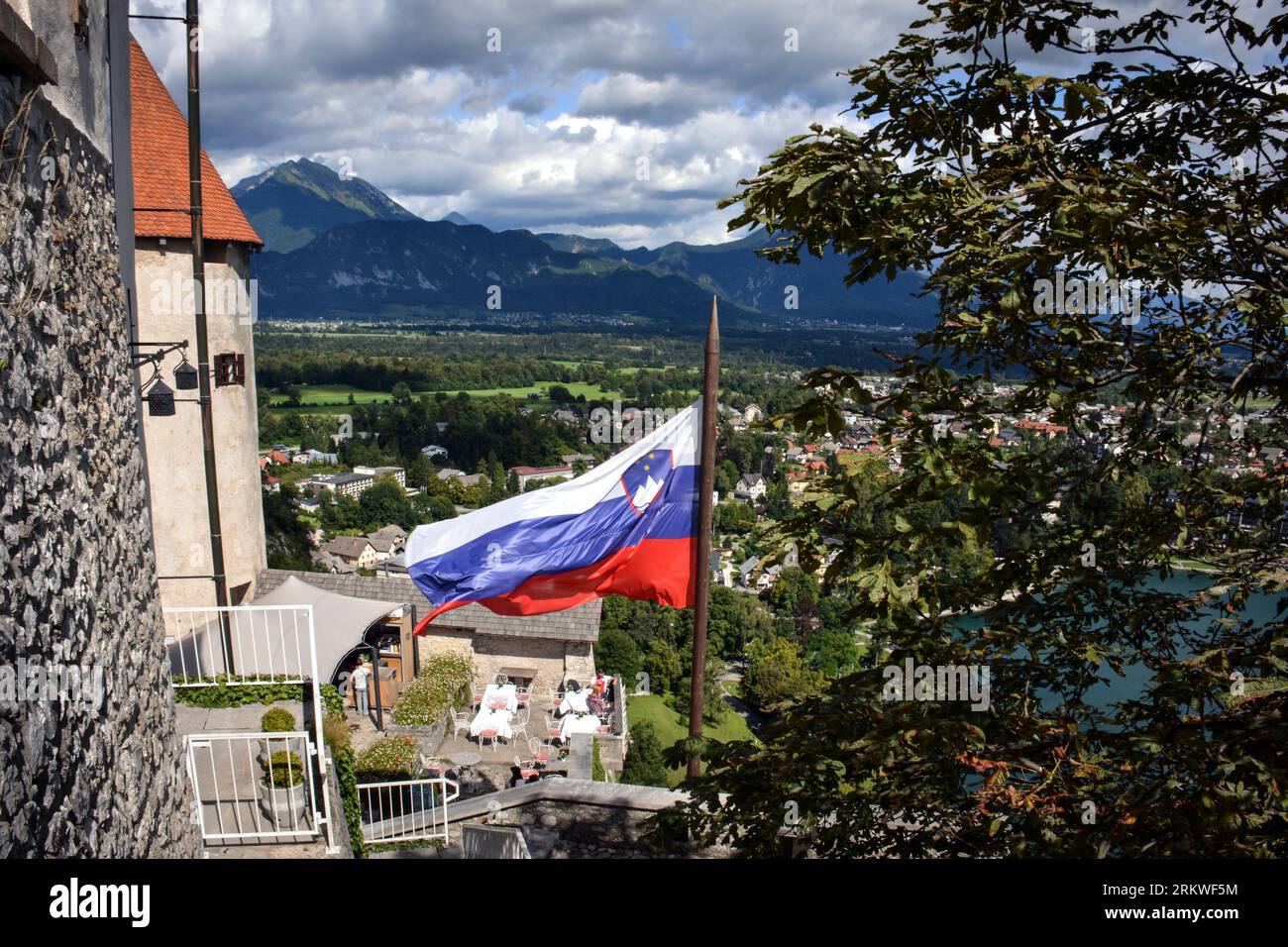 La bandiera della Slovenia e le Alpi di Bled viste dalle mura del castello Foto Stock