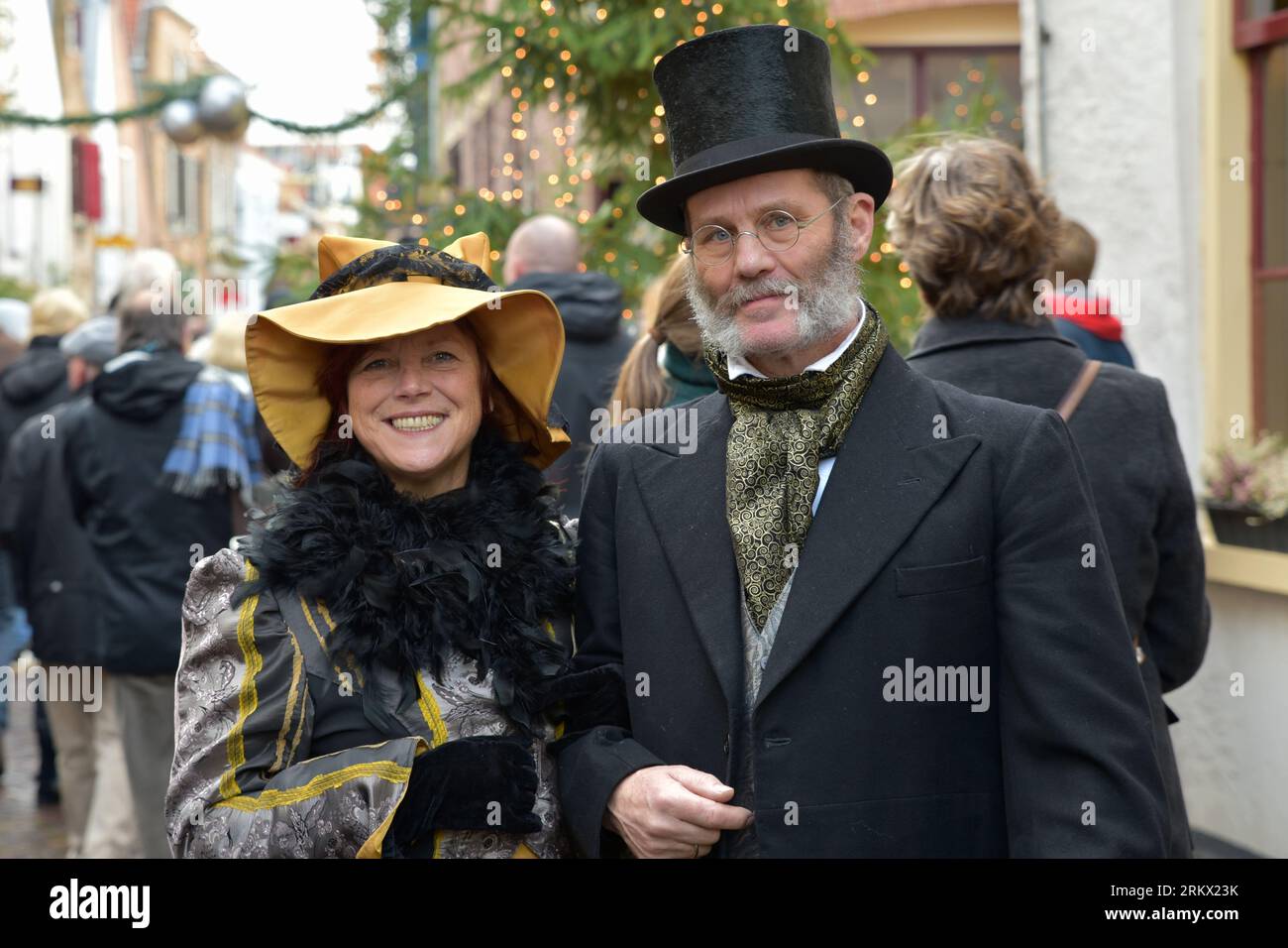 Coppia vestita in stile Dickens passeggia per le strade trafficate di un quartiere del Deventer nel fine settimana prima di Natale Foto Stock