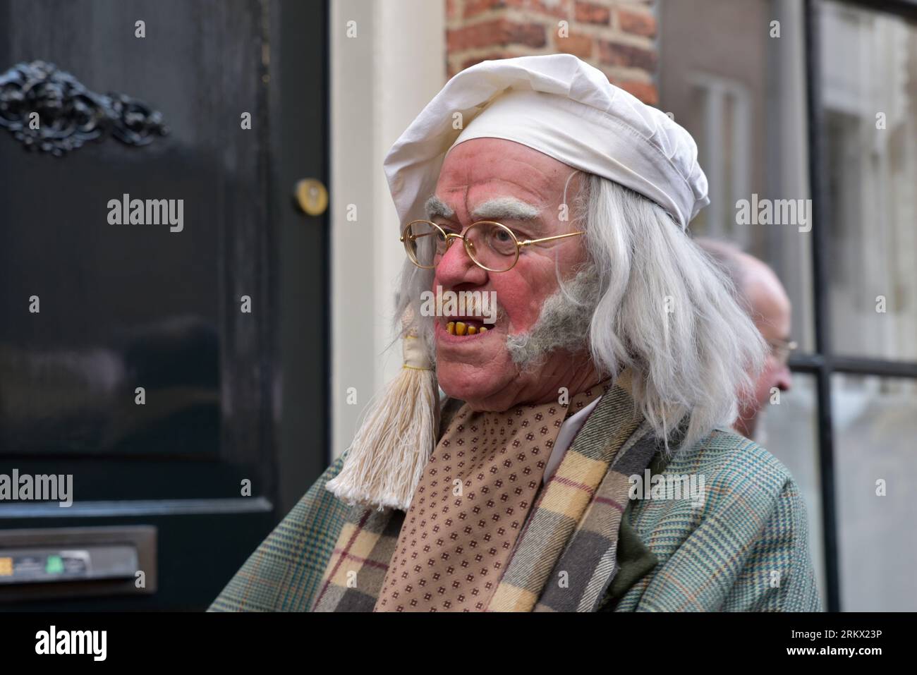 Attore con cappello bianco, lunghi capelli grigi e denti gialliti durante la Dickens Feast a Deventer Foto Stock