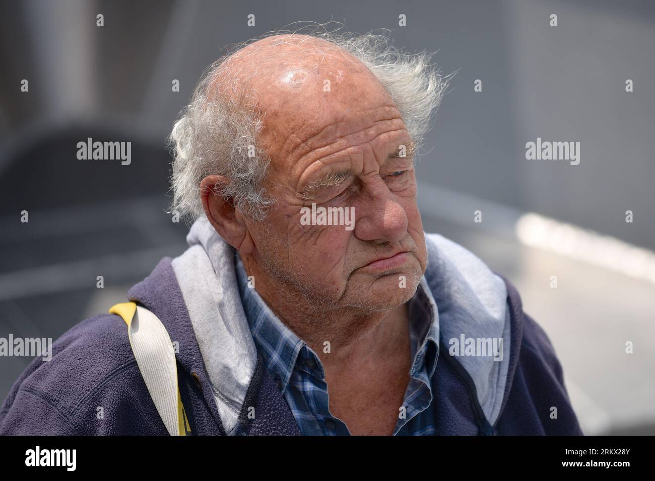 Ritratto di un pescatore vitale con un viso rugoso e un'espressione facciale seria, guardando qualcosa in lontananza Foto Stock