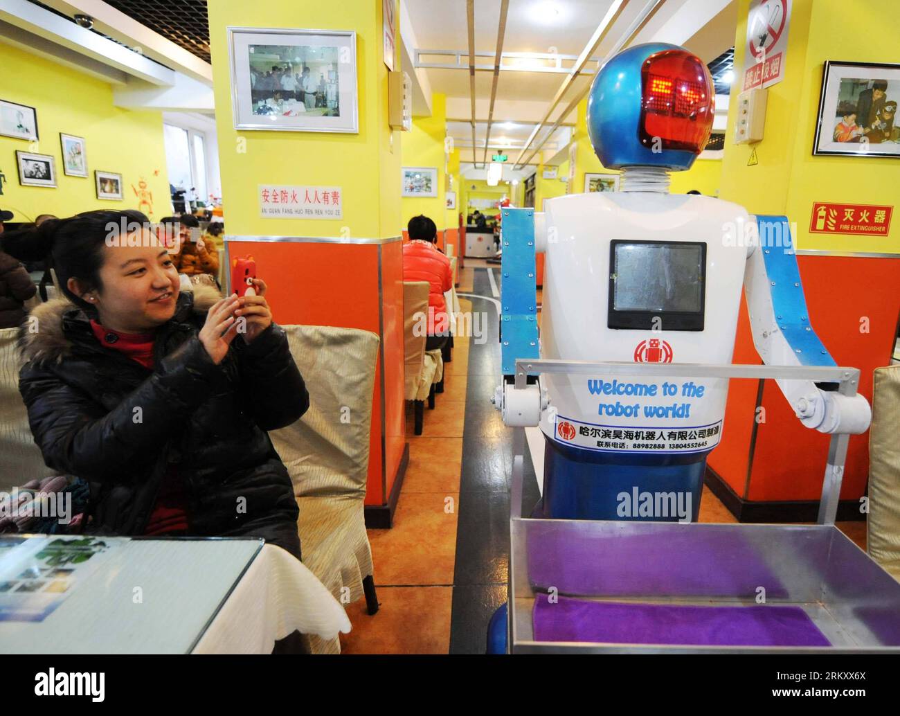 Bildnummer: 59103143 Datum: 18.01.2013 Copyright: imago/Xinhua (130118) -- HARBIN, 18 gennaio 2013 (Xinhua) -- Un cliente scatta foto di un robot che serve piatti in un ristorante a tema robot a Harbin, capitale della provincia di Heilongjiang della Cina nord-orientale, 18 gennaio 2013. Aperto nel giugno del 2012, il ristorante ha guadagnato fama utilizzando un totale di 20 robot per cucinare i pasti, consegnare i piatti e salutare i clienti. (Xinhua/Wang Jianwei) (zc) RISTORANTE A TEMA CHINA-HEILONGJIANG-HARBIN-ROBOT (CN) PUBLICATIONxNOTxINxCHN Gesellschaft Gastronomie Erlebnisgastronomie kurios Komik Roboter Kellner Fotostory x0x x Foto Stock