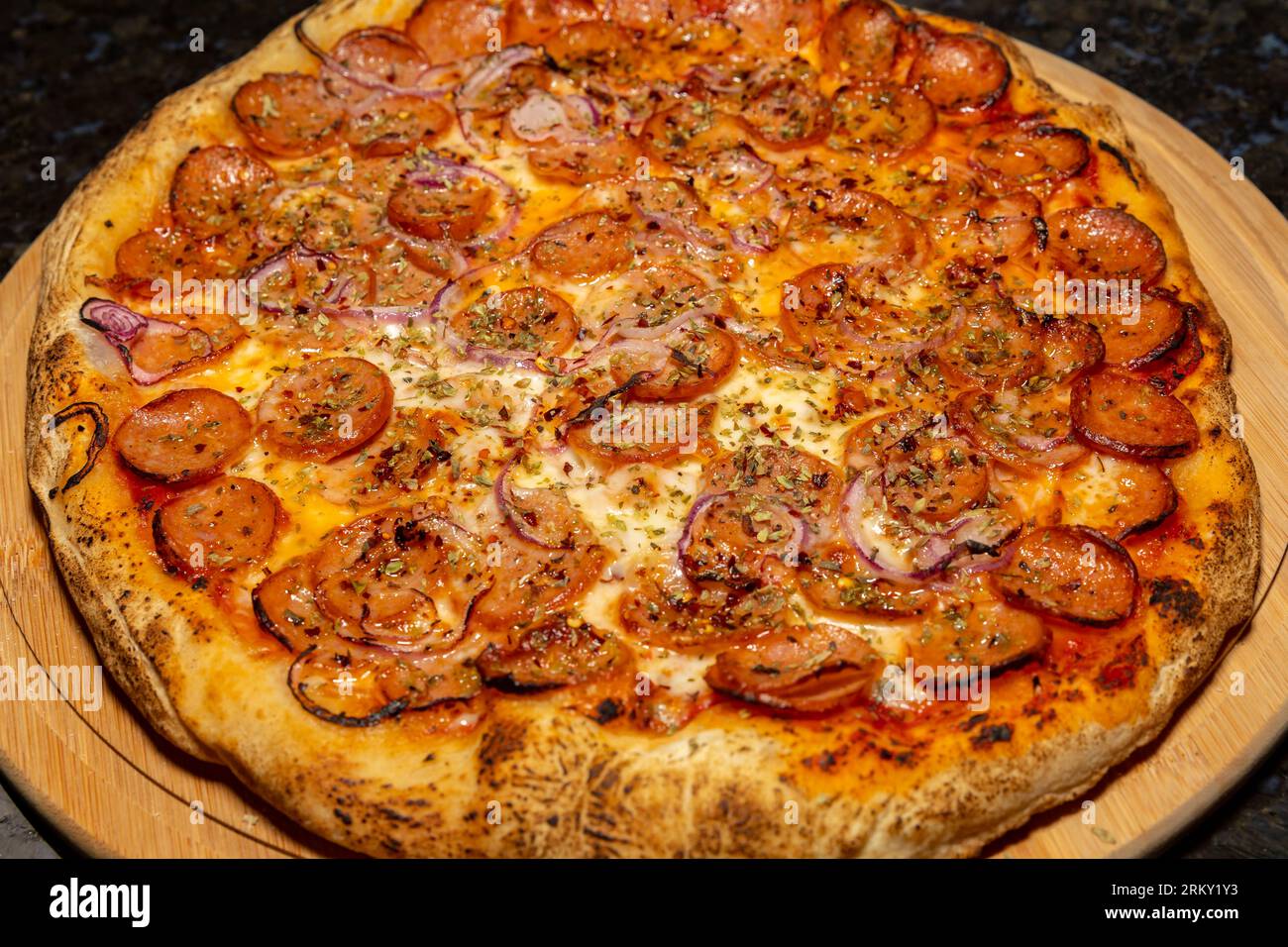 Tradizionale pizza rustica con peperoni, olive nere, cipolla e basilico Foto Stock