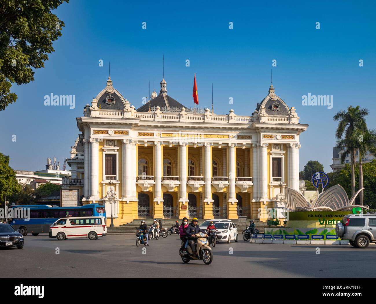 Il traffico passa per la splendida Hanoi Opera House, risalente all'epoca coloniale francese, o Nha Hat Lon, nel centro di Hanoi, in Vietnam. Modellato sul Palais Garnier di Parigi, Foto Stock