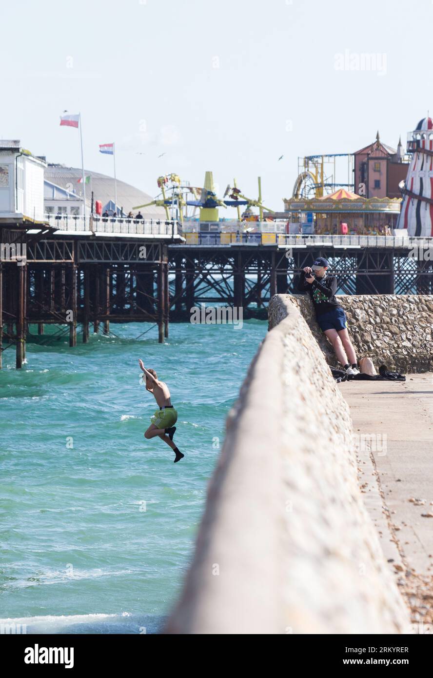 Ragazzo che salta dal molo di Brighton in estate Foto Stock
