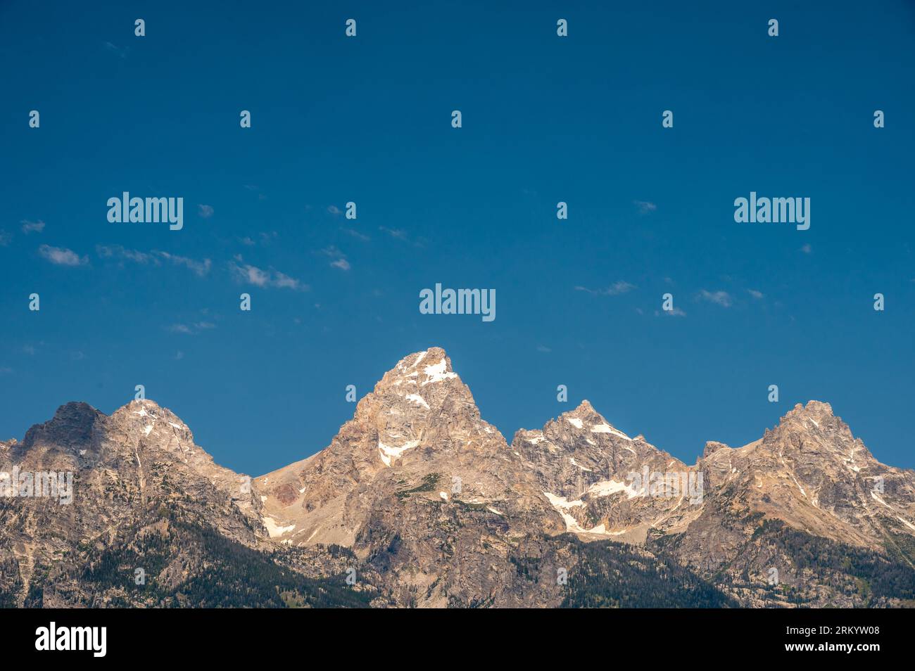 I Grand Tetons si schiudono contro Blue Sky e Sparse Clouds nel Wyoming Foto Stock