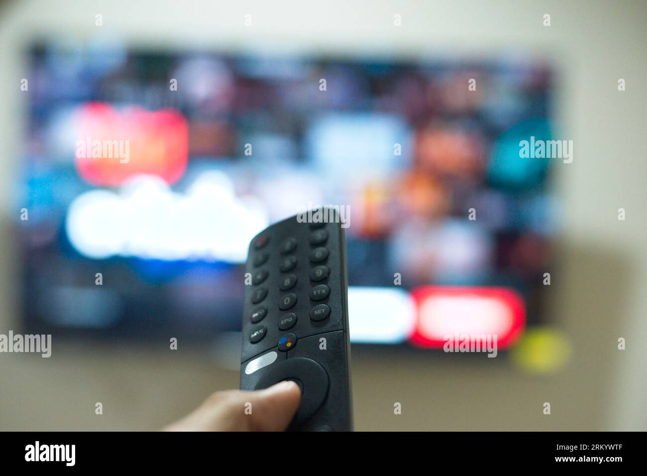 Grazie al telecomando TV, puoi passare da una serie TV all'altra dalla piattaforma di servizi di streaming. Il nuovo modo di godersi l'intrattenimento a casa. Foto Stock