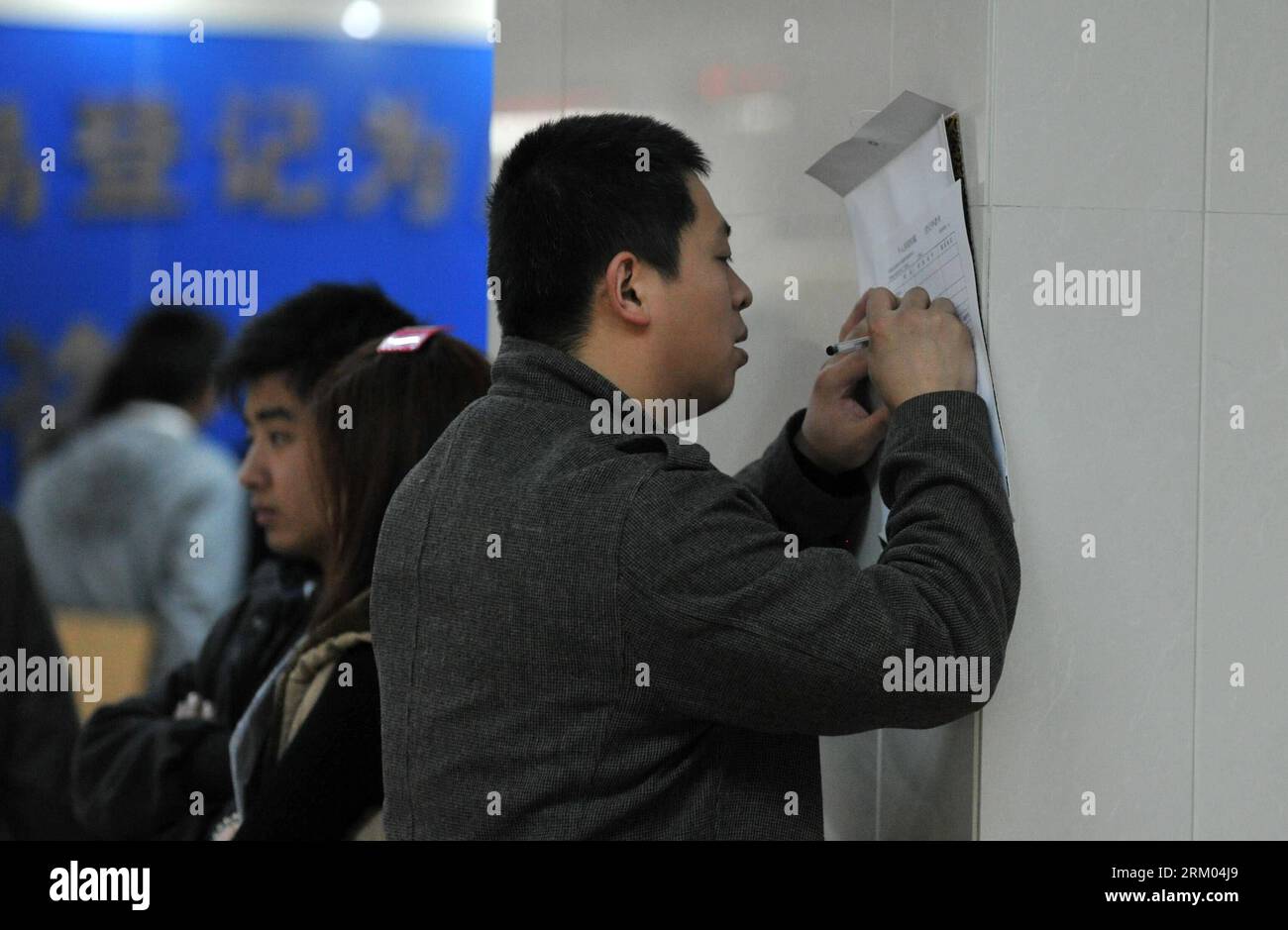 Bildnummer: 59320146 Datum: 08.03.2013 Copyright: imago/Xinhua (130308) -- SHIJIAZHUANG, 8 marzo 2013 (Xinhua) -- Un cittadino compila Un modulo di informazioni sull'alloggio presso il centro per le transazioni immobiliari di Shijiazhuang, nella provincia di Hebei nella Cina settentrionale, 8 marzo 2013. In questi giorni, le transazioni immobiliari di seconda mano aumentano in città, mentre acquirenti e venditori si affrettano a prendere l'ultimo autobus e a concludere le loro trattative prima che le nuove misure siano pienamente attuate. Secondo la dichiarazione del Consiglio di Stato, i proprietari di case che vendono proprietà dovranno pagare un'imposta sulle plusvalenze del 20% dell'utile che mak Foto Stock