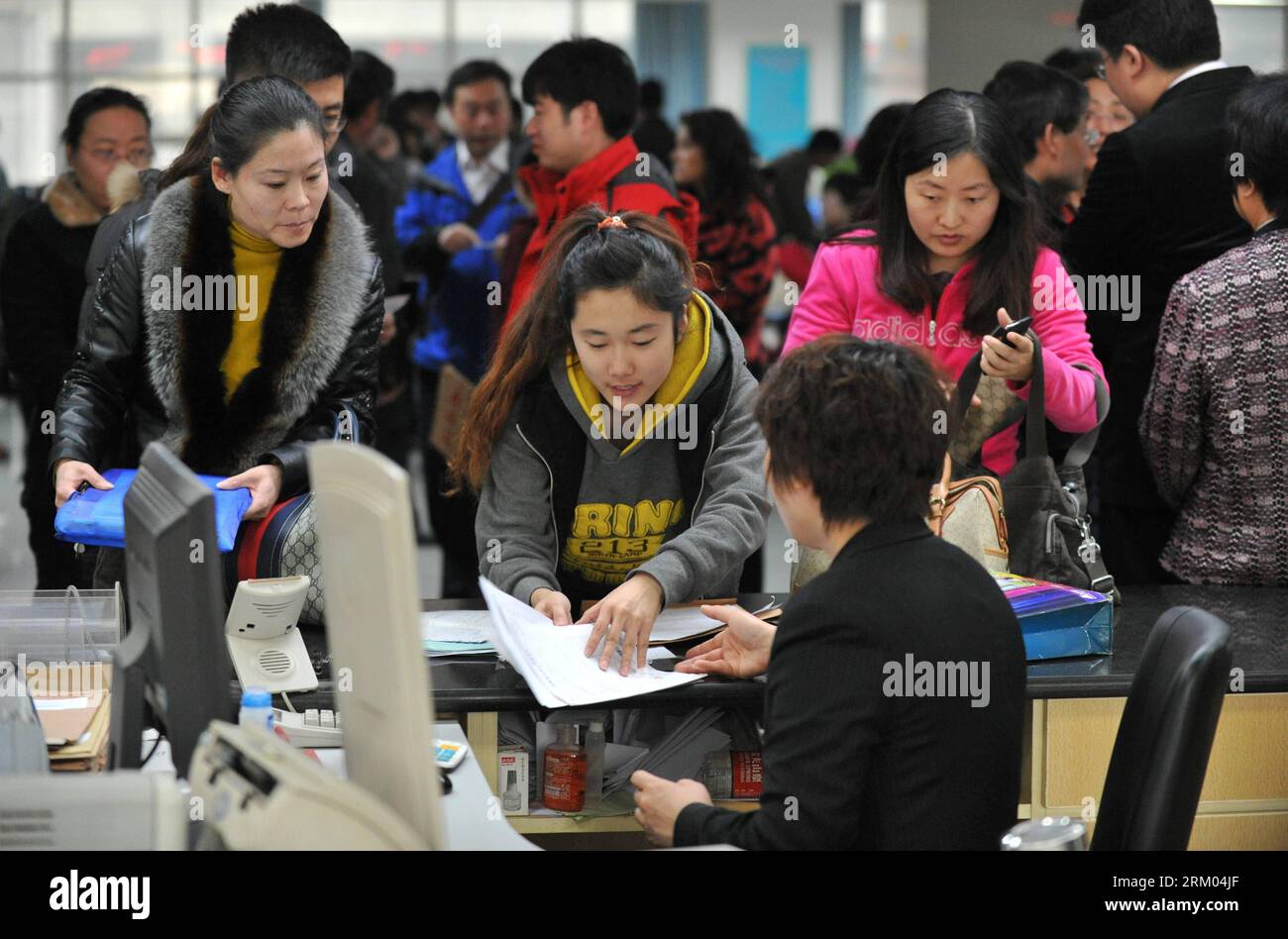 Bildnummer: 59320144 Datum: 08.03.2013 Copyright: imago/Xinhua (130308) -- SHIJIAZHUANG, 8 marzo 2013 (Xinhua) -- i cittadini conducono transazioni abitative presso il centro per le transazioni abitative di Shijiazhuang, nella provincia di Hebei nella Cina settentrionale, 8 marzo 2013. In questi giorni, le transazioni immobiliari di seconda mano aumentano in città, mentre acquirenti e venditori si affrettano a prendere l'ultimo autobus e a concludere le loro trattative prima che le nuove misure siano pienamente attuate. Secondo la dichiarazione del Consiglio di Stato, i proprietari di case che vendono proprietà dovranno pagare un'imposta sulle plusvalenze del 20% del profitto che realizzano sul Foto Stock